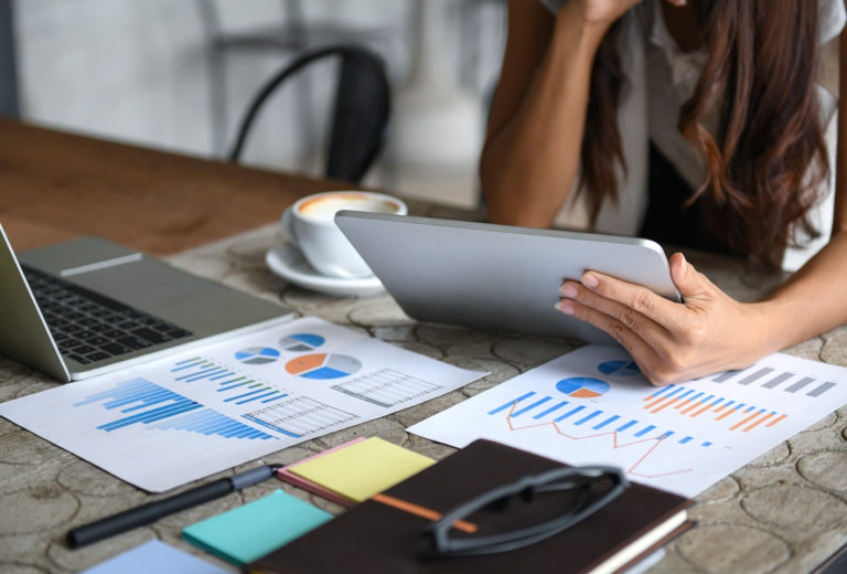 Businesswomen using tablet for marketing and SEO analysis during a meeting.