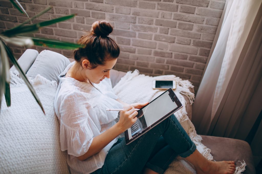 Woman working remotely on tablet, illustrating remote employee burnout management