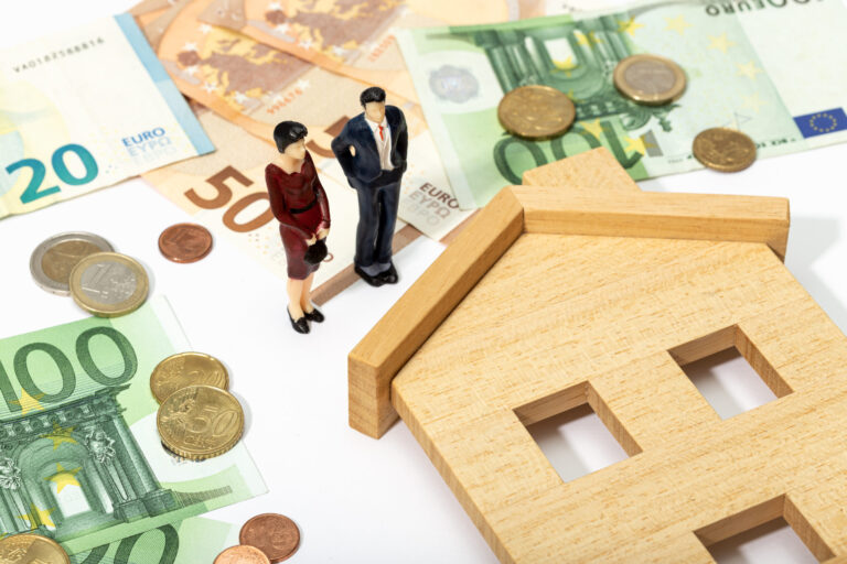 Real estate investing concept with miniature figures and euro currency