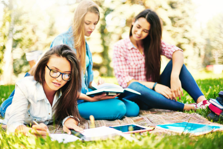 a group of girls studying outside
